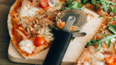 Pizzaschneider auf geschnittener Pizza